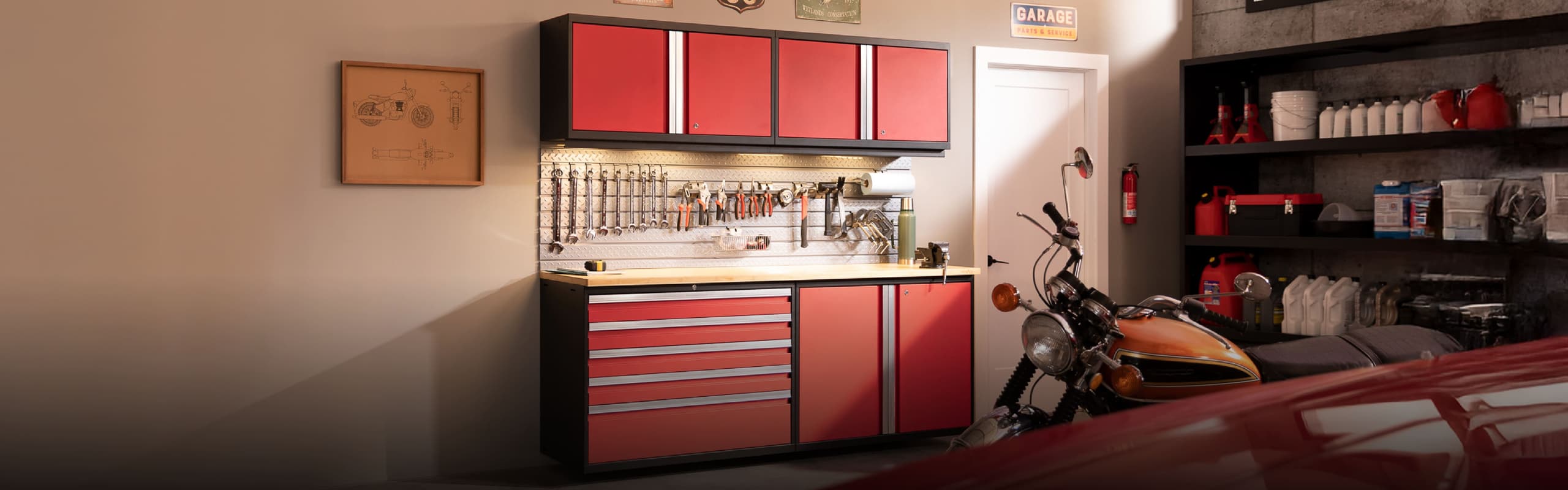 Red Bold Series garage cabinets with a wooden workbench, pegboard wall and a motorcycle