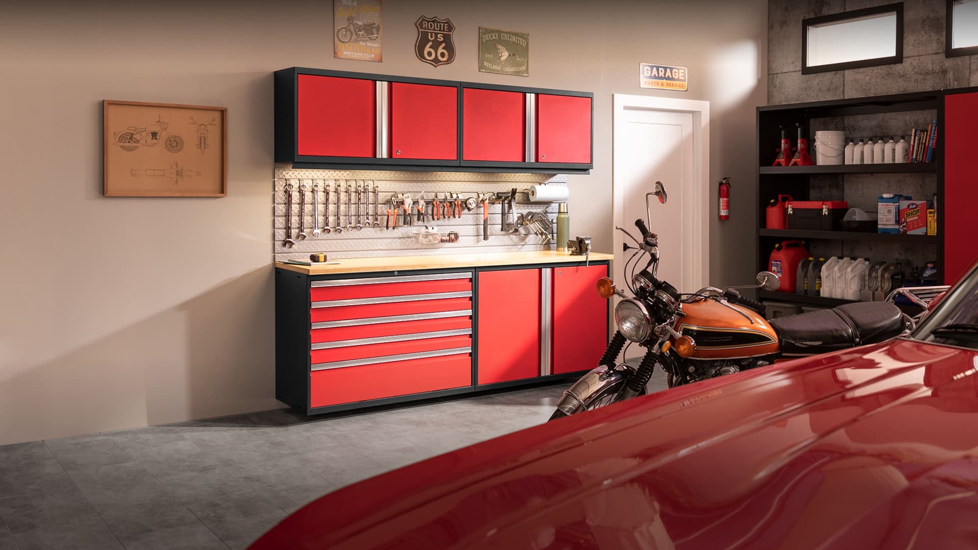 NewAge grey garage cabinets with a stainless-top workbench and an overhead tire rack