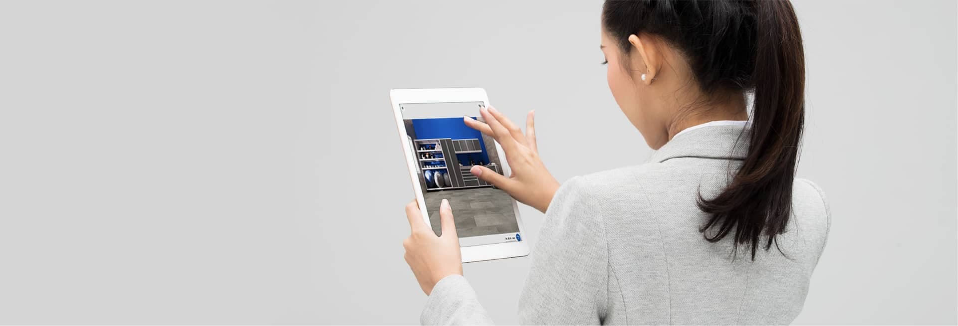 Woman using a tablet app to visualize garage flooring and cabinets in augmented reality