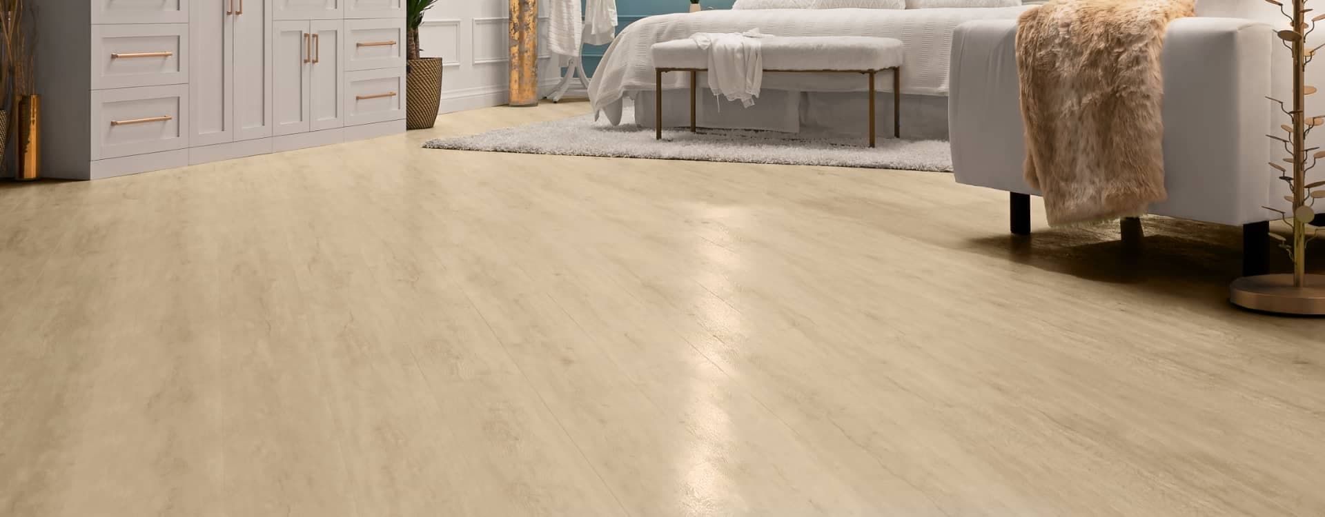 A bright bedroom with cream-colored luxury vinyl plank flooring.