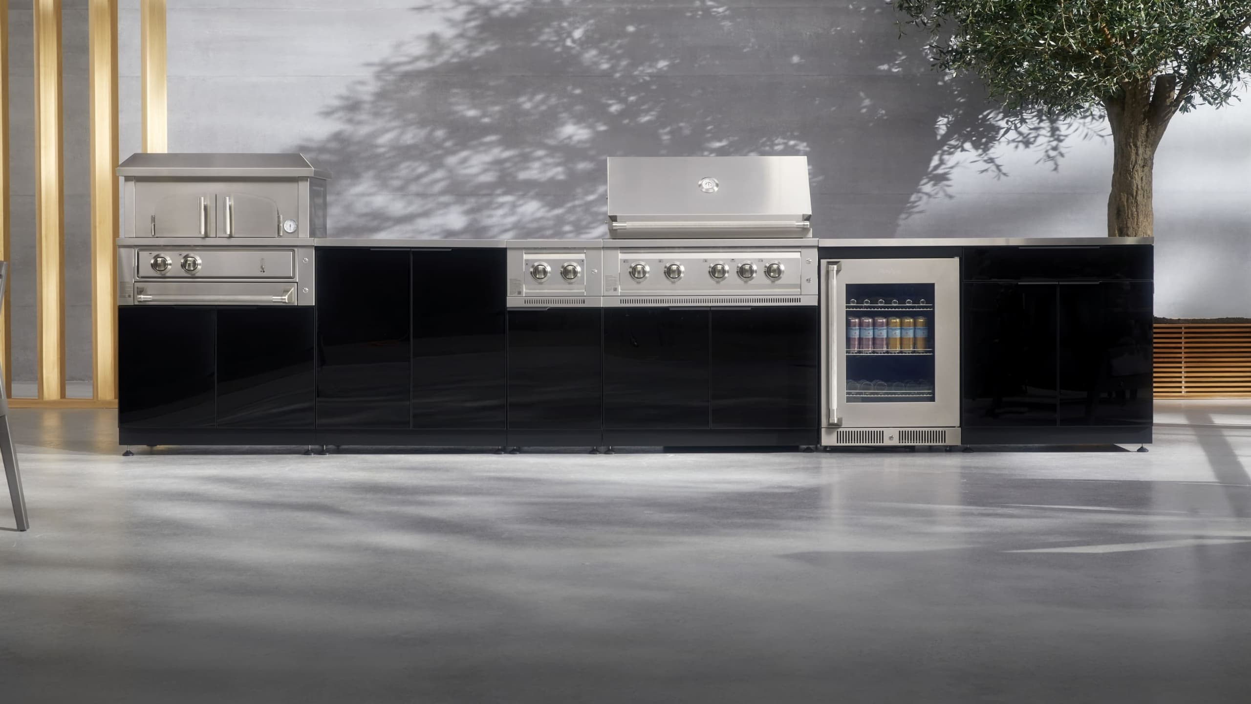 NewAge outdoor kitchen with stone-clad surrounds, a kamado grill and built-in gas grill