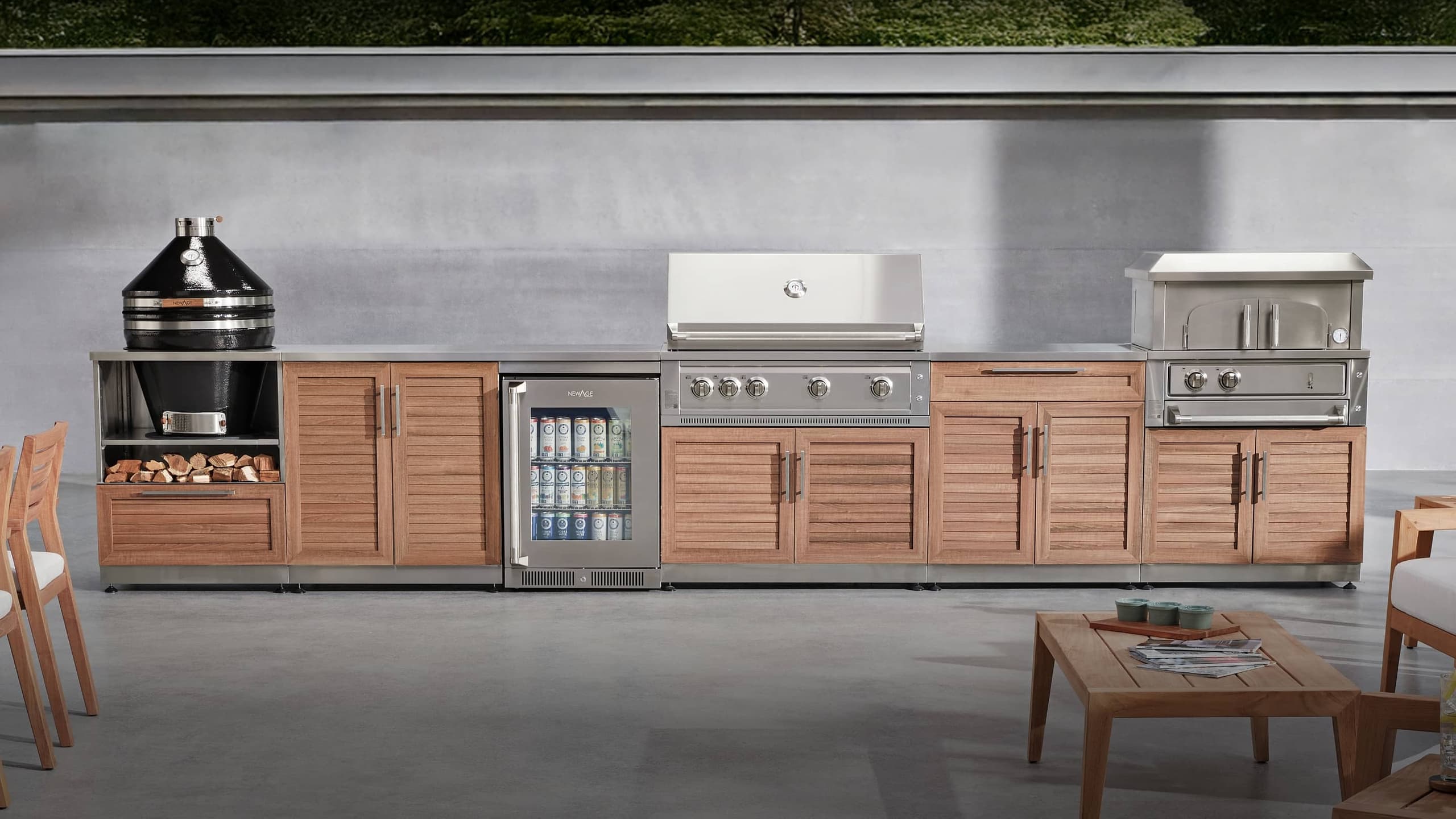 NewAge outdoor kitchen with stone-clad surrounds, a kamado grill and built-in gas grill