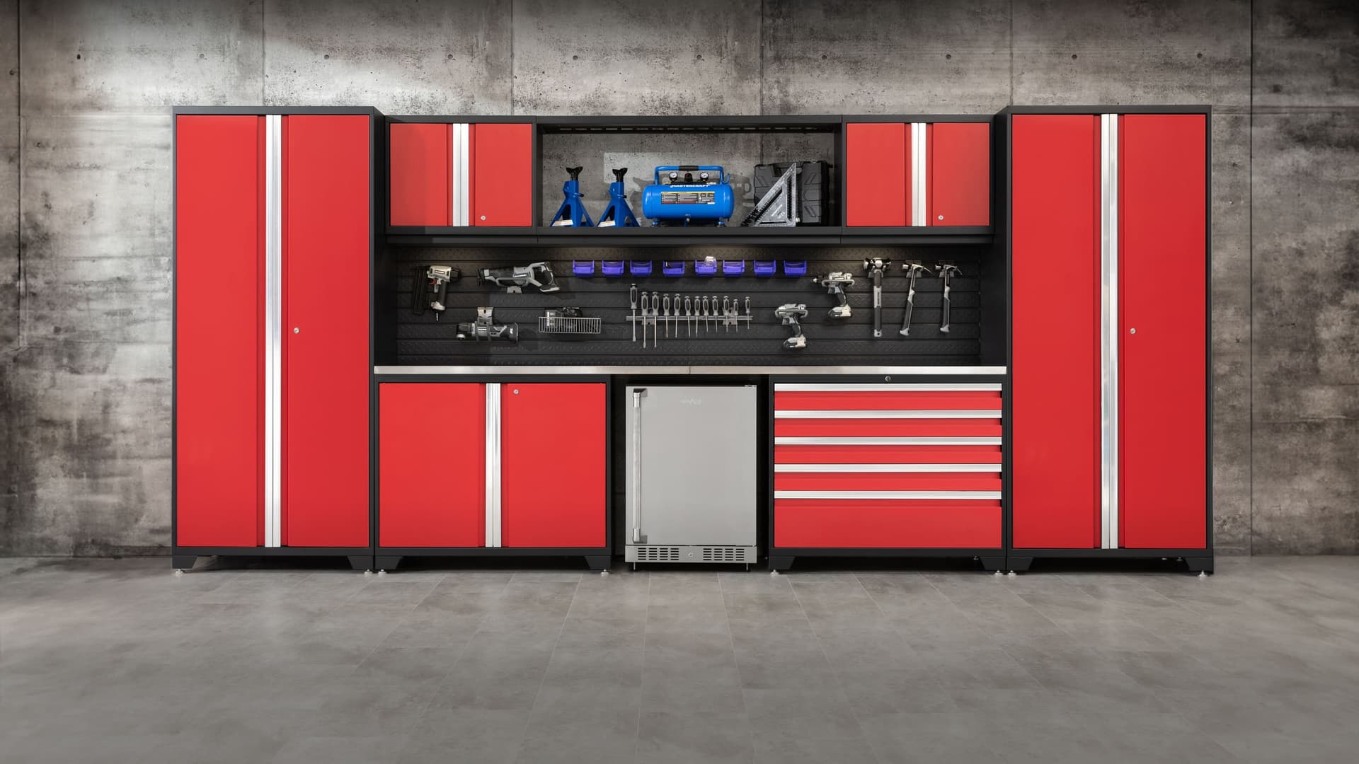 NewAge red garage cabinet set with tall lockers, a tool-hung pegboard, stainless fridge and a drawer tool chest
