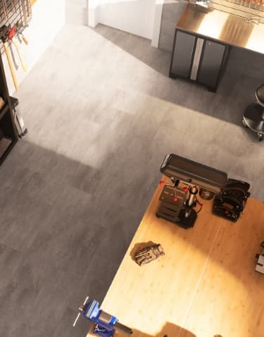 Workshop from above: lumber rack, workbench with power tools, wall cabinets, gray tile