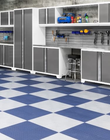 White cabinets and a steel pegboard tool wall on blue and white checkerboard floor tiles