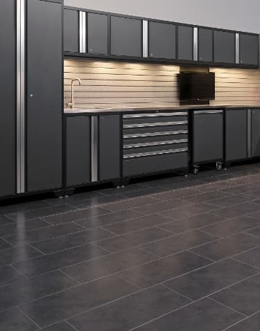 Dark gray floor tiles in a kitchenette setup with gray cabinets, a sink and wall TVs