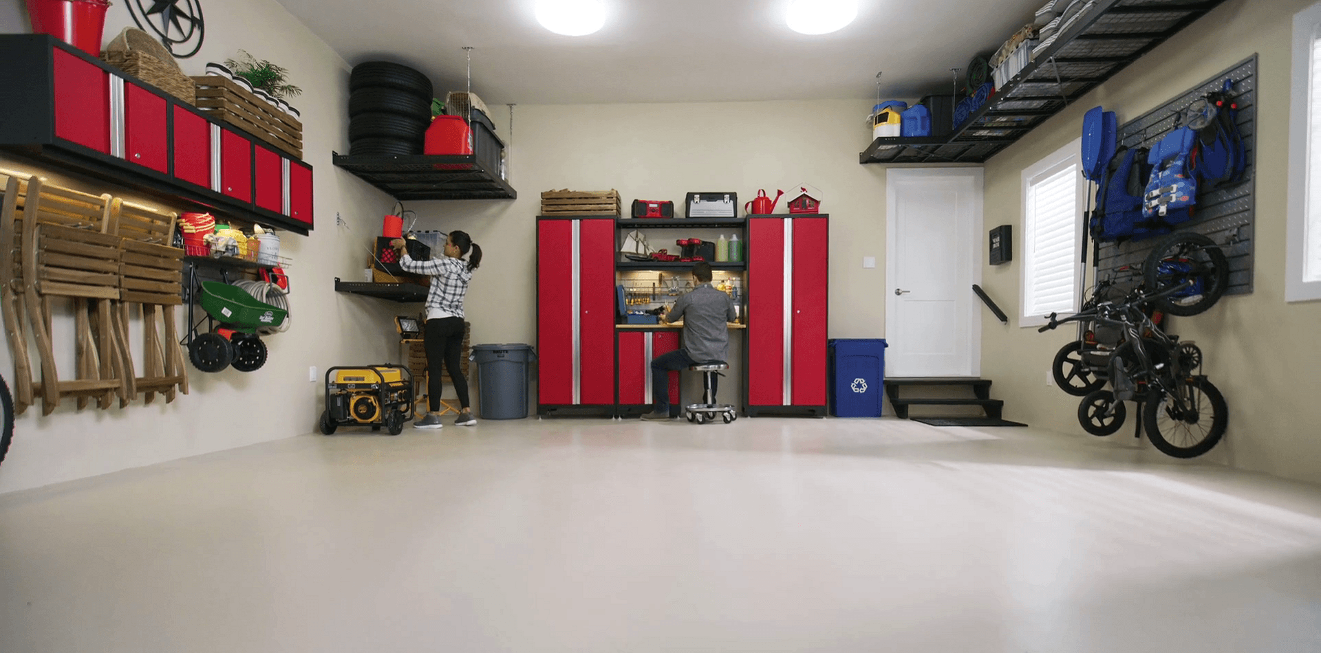 Garage with red overhead and floor cabinets, workbench, slatwall and overhead racks